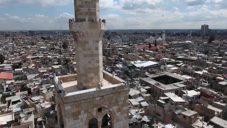 panorama of a mosque in damascus in syria under cloudy and sunny sky. we ca see the ancient city through the horizon - aerial view with a drone