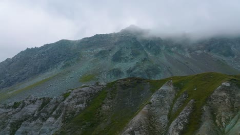 Aerial-shot-discovering-summit-of-misty-mountain-in-Alps,-France