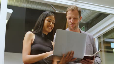 colegas de negocios discutiendo sobre una computadora portátil 4k