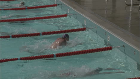 los nadadores llegan al borde de la piscina, dan la vuelta y comienzan a nadar de regreso