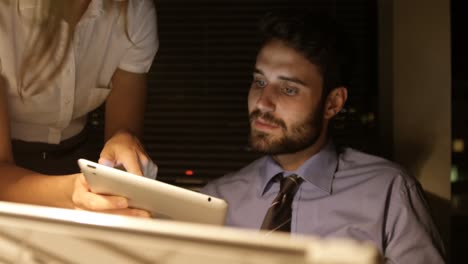 colleagues discussing over digital tablet