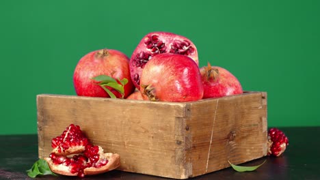wooden box with fresh pomegranates rotates slowly.