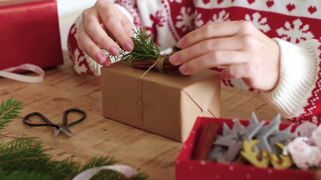 Girl's hands preparing christmas gifts at home