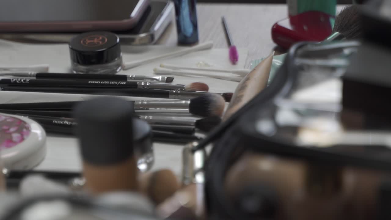 Various utensils for make-up and small makup bags on a table, among other things, brushes