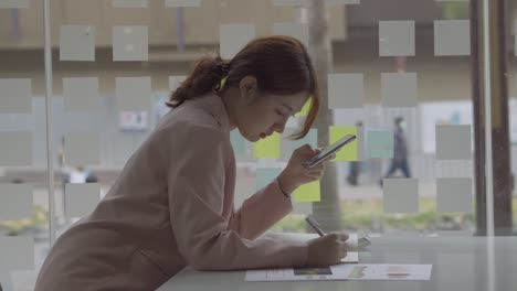 las mujeres asiáticas usan teléfonos inteligentes para hacer el trabajo de contabilidad financiera.