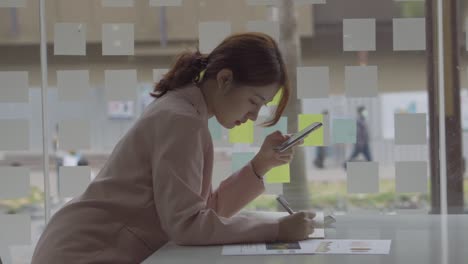 asian women use smartphones to do financial accounting work.