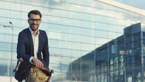 Portrait-shot-of-attractive-man-wearing-glasses-and-sitting-on-his-bike