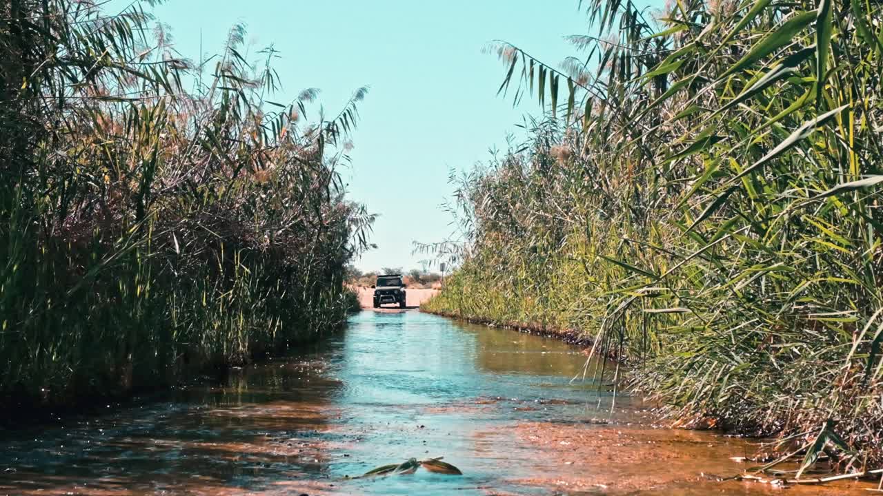 Small four wheel drive vehicle crossing a river in the Northern Cape of South Africa