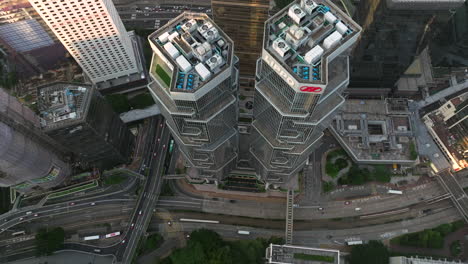 Drone-lifting-tilt-shot-of-the-high-Lippo-Towers-and-busy-highways-in-Hong-Kong