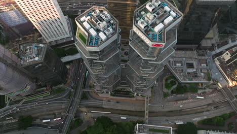 drone levantando tiro inclinado de las altas torres de lipopo y carreteras concurridas en hong kong