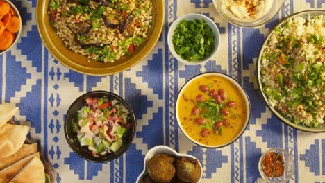 arabian cuisine top view. bulgur with eggplant, falafel, bean soup, couscous with chicken. traditional middle eastern culture. moutabal and vegetable salad in bowls, pita. delicious rice with meat