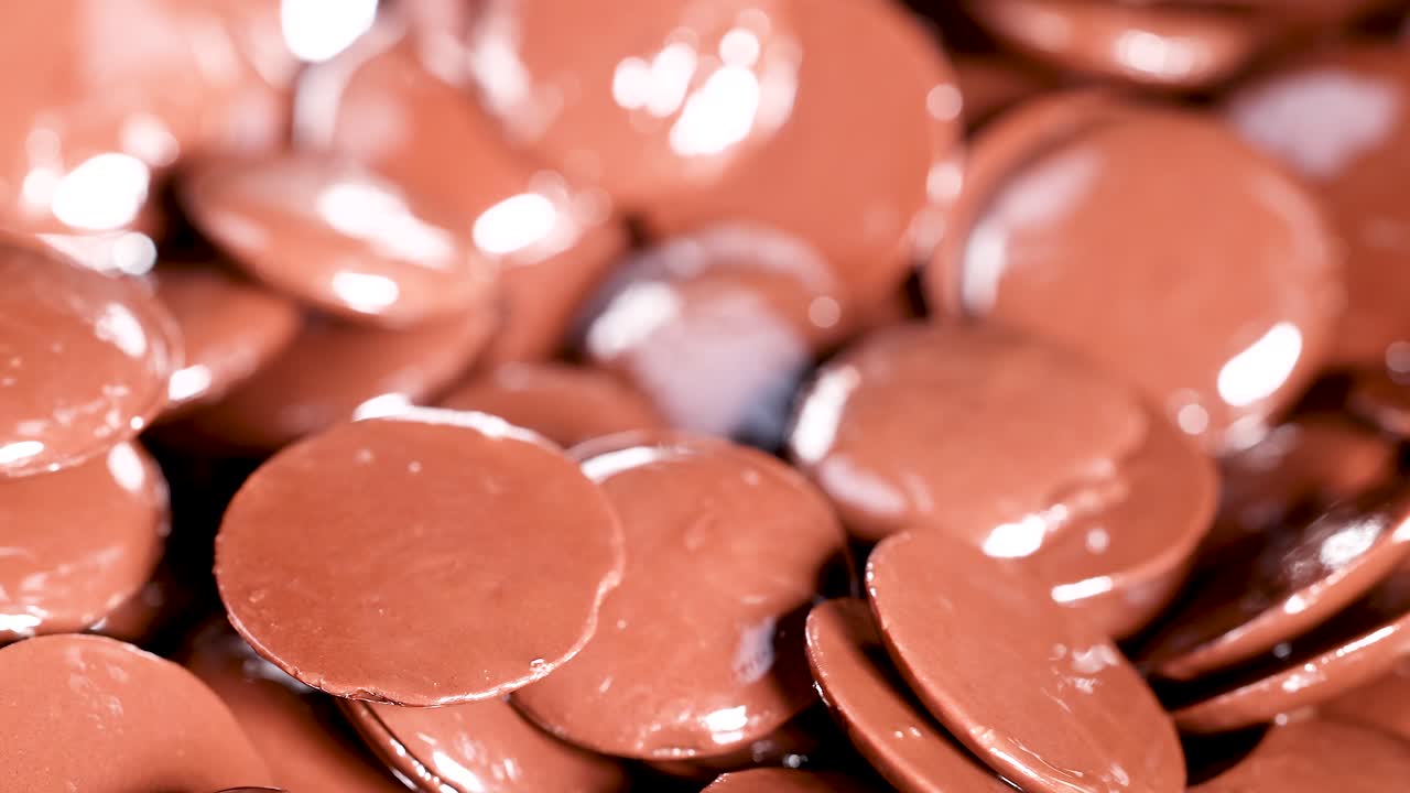 cuchara mezclando discos de chocolate brillantes en movimiento