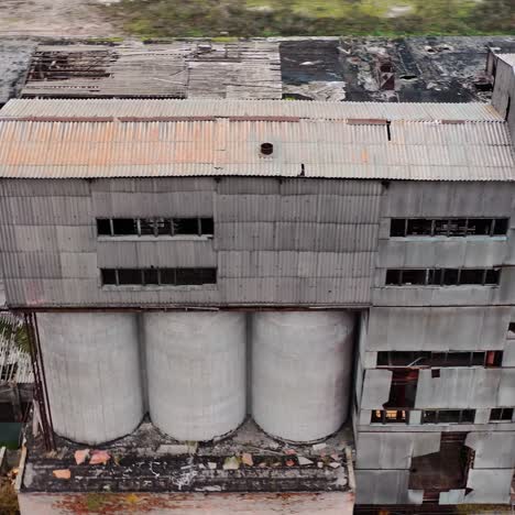 ruined factory with damaged roof. abandoned buildings on the field of military actions. destroyed architecture. aerial view.