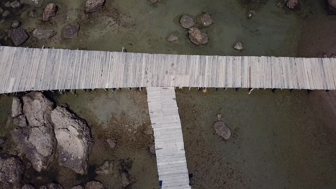 바다와 해변을 연결하는 바위 해변의 나무 산책로