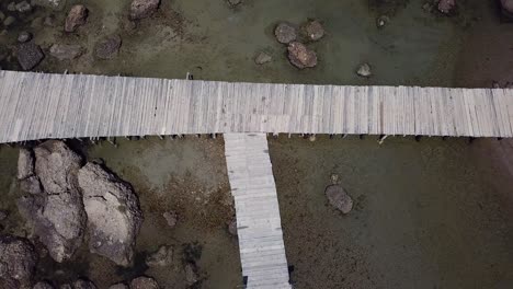 paseo marítimo de madera en la playa rocosa que conecta el mar con la playa