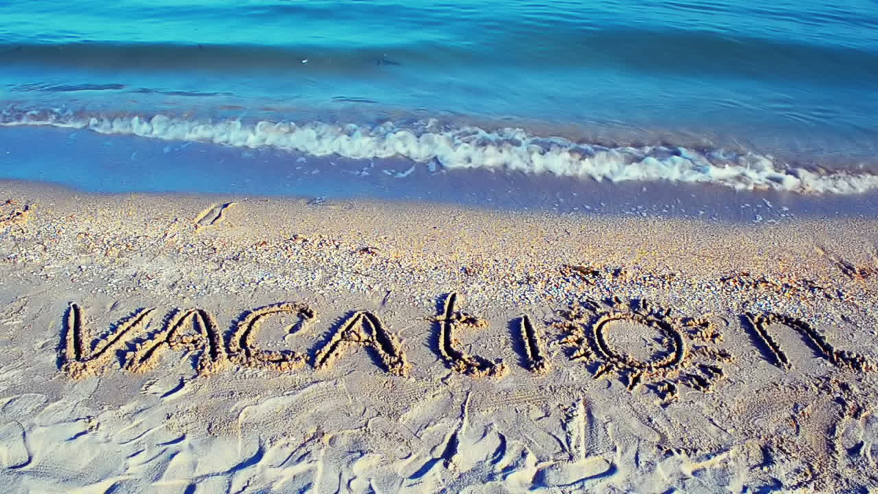 The inscription Vacation on sand. Inscription on sand
