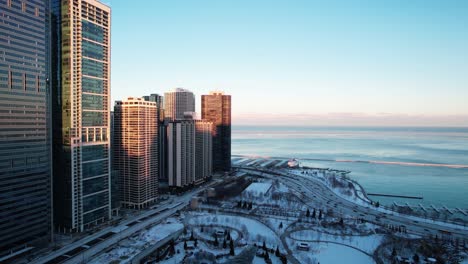 lake michigan and part of chicago buildings with lakeshore drive in view, aerial at the sunset