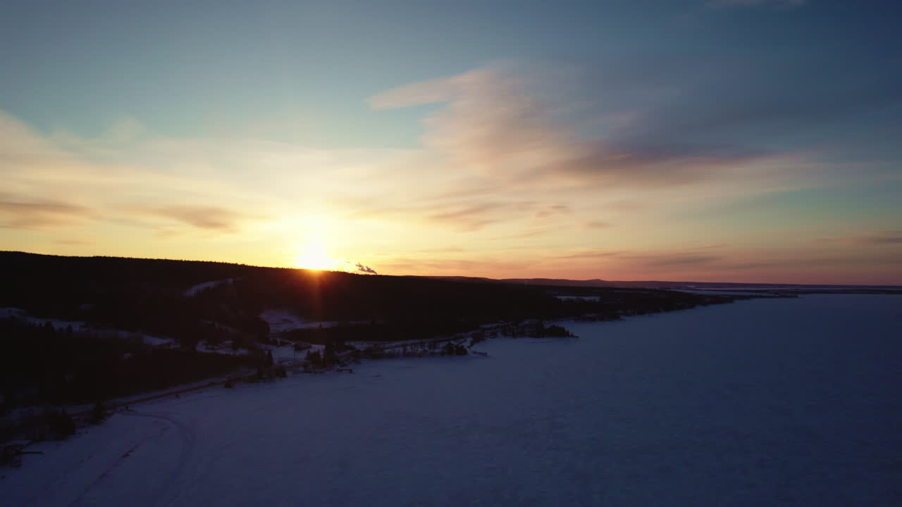 drone volando sobre un lago congelado en canadá en la hora dorada