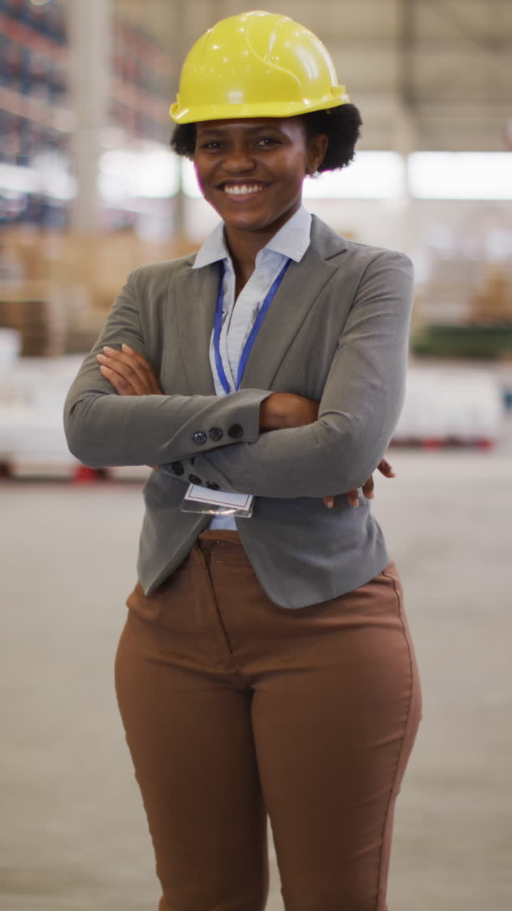 video vertical del retrato de una trabajadora afroamericana con casco en un almacén