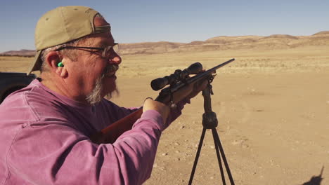 practicing gun shooting in desert with rifle