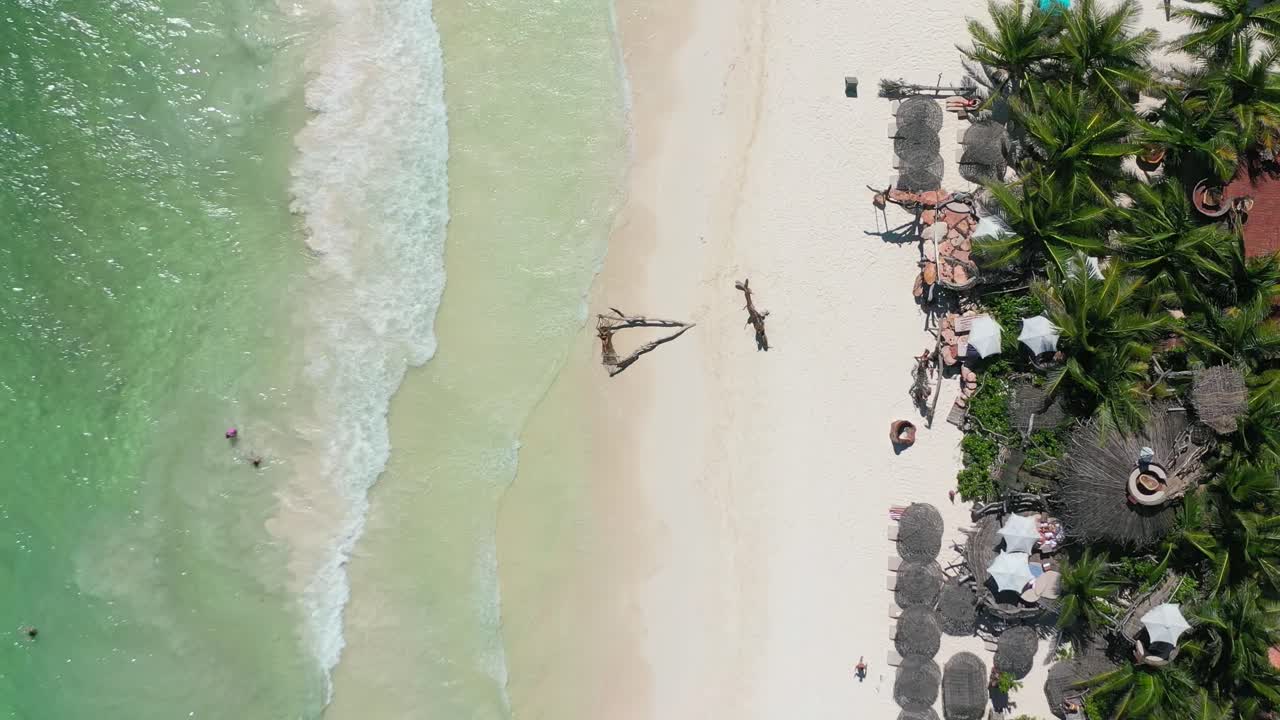 las olas del océano verde esmeralda se estrellan en la playa tropical de arena blanca en la zona hotelera de tulum en un día soleado, antena arriba hacia abajo