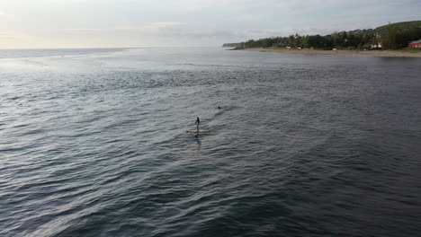 Paddleboarder-Y-Un-Surfista-Disfrutando-De-Las-Tranquilas-Aguas-Alrededor-De-La-Isla-De-La-Reunión-Mientras-Se-Pone-El-Sol