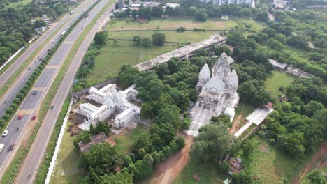 aerial view of a white temple next to a highway