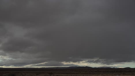 storm clouds form over the mojave desert's arid landscape then rain pours down in a heavy cloudburst - time lapse