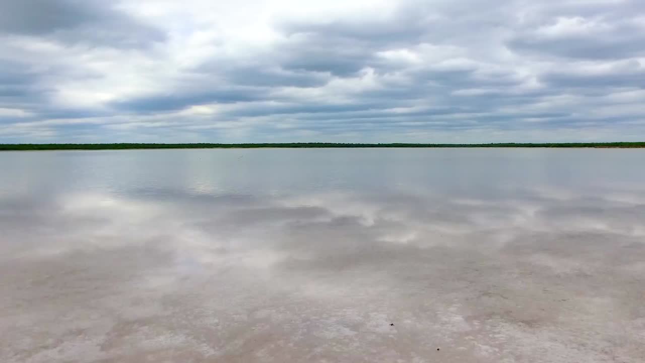 toma rápida de un lago salado local con bonitas nubes y árboles en el fondo