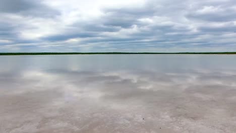 fast flying shot of a local salt lake with nice clouds and trees in the background