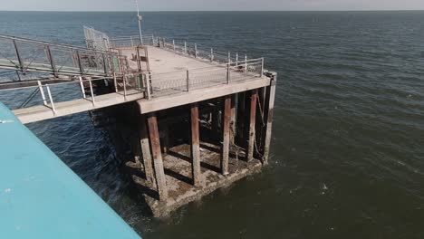 old rusty fenced fishing platform at end of llandudno pier overlooking ocean