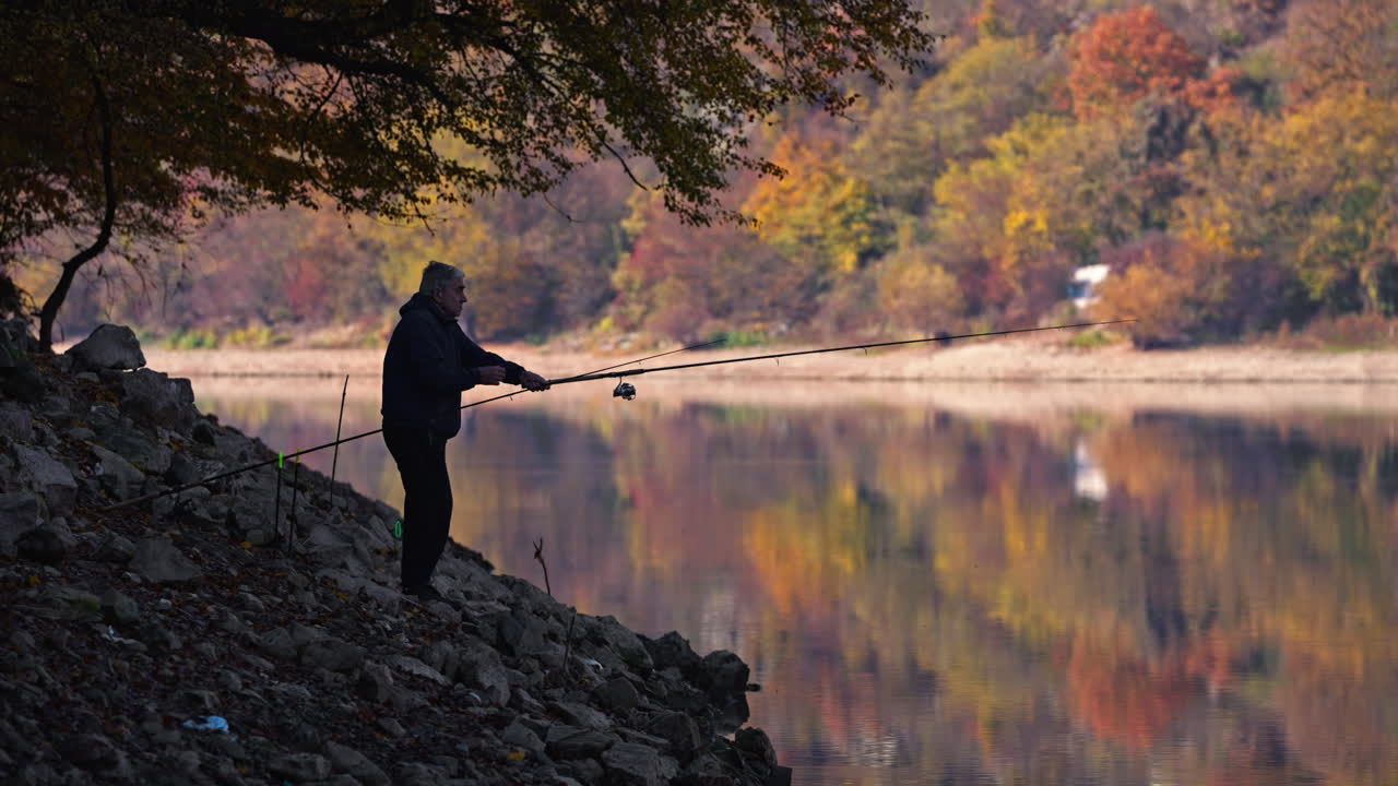 Fisherman enjoying a peaceful day of fishing by the lake in autumn