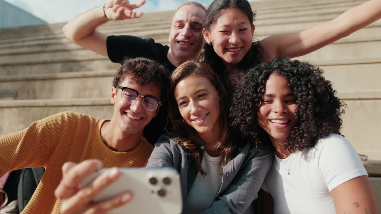 Group of joyfull happy students taking a selfie or video with their phone