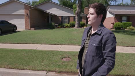 man looks emotionally in the distance of a neighborhood