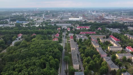 Flyover-of-Soivet-era-Polish-blocs-and-Grupa-Azoty-chemical-plant-factory-in-Moscice-industrial-district-in-Tarnow,-Poland---Industrial-pollution,-smog,-global-warming--4K-30FPS-Tracking-Forward