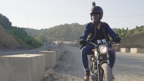 motorcycle rider on a dirt road through a mountainous landscape