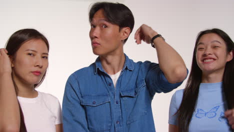 Group-Of-Young-Friends-In-Front-Of-White-Studio-Background-Posing-For-Photo-Booth-Style-Portraits-5