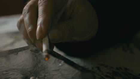 hand holding burning cigarette over dirty glass ashtray close-up slide