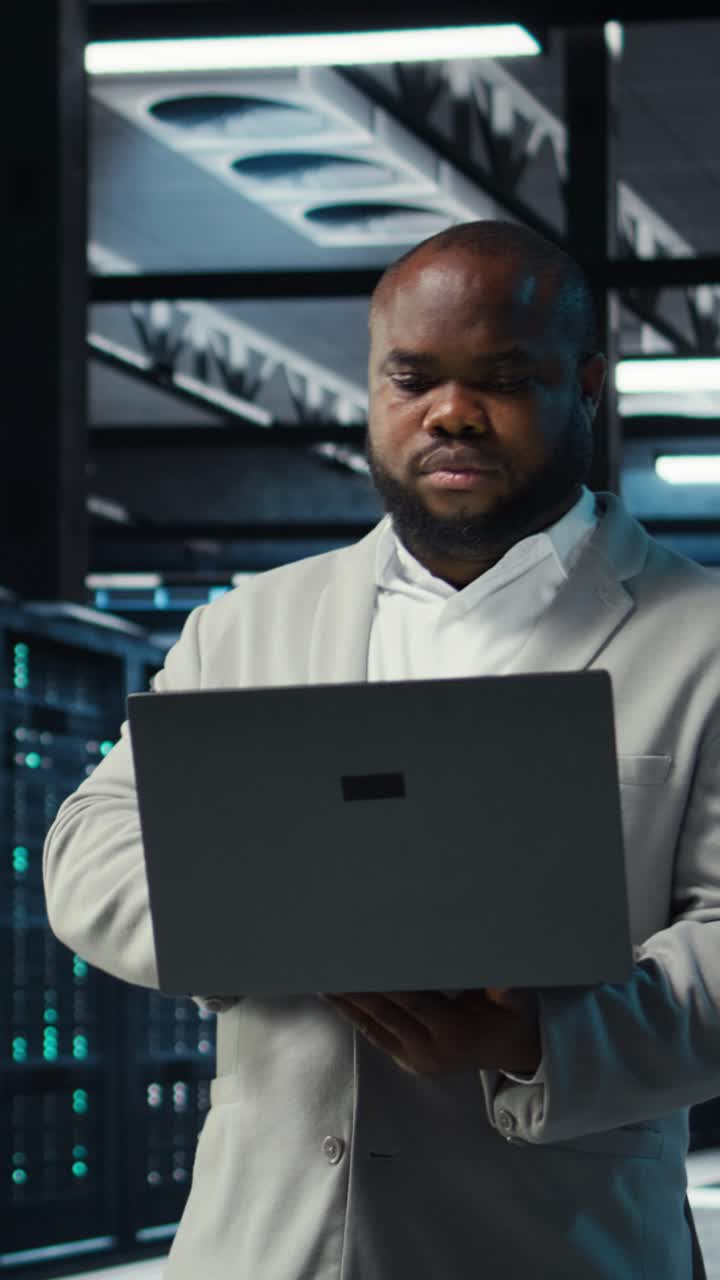 Vertical video Data center engineer analyzing equipment performance, resolving technical issues