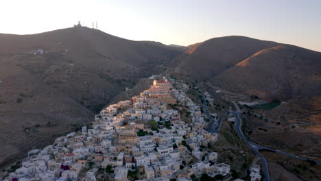 aerial: slow panning drone shot of catholic saint george church of ermoupoli city in syros island, greece during sunset