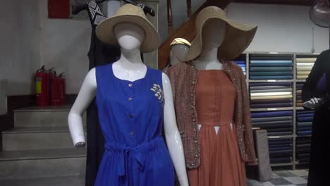 blue and other dresses on dolls in a big shop