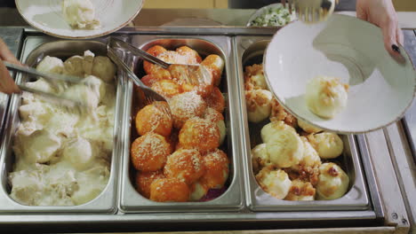 visitors put food on their plates. self service restaurant. view from above