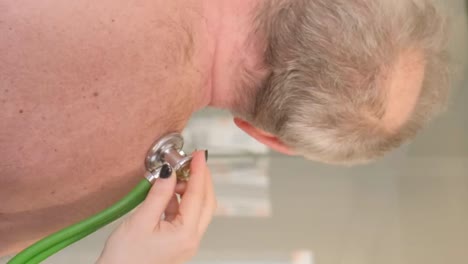 a female doctor listens to the work of the heart using a stethoscope. physical examination. taking care of your health. vertical video.