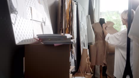 woman tailor choosing clothes pieces in the sewing workshop 2