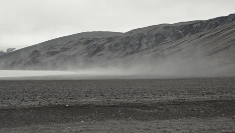 beach with steam rising from ocean water over island, active volcano