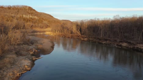 paisaje fluvial de invierno con colinas y bosques