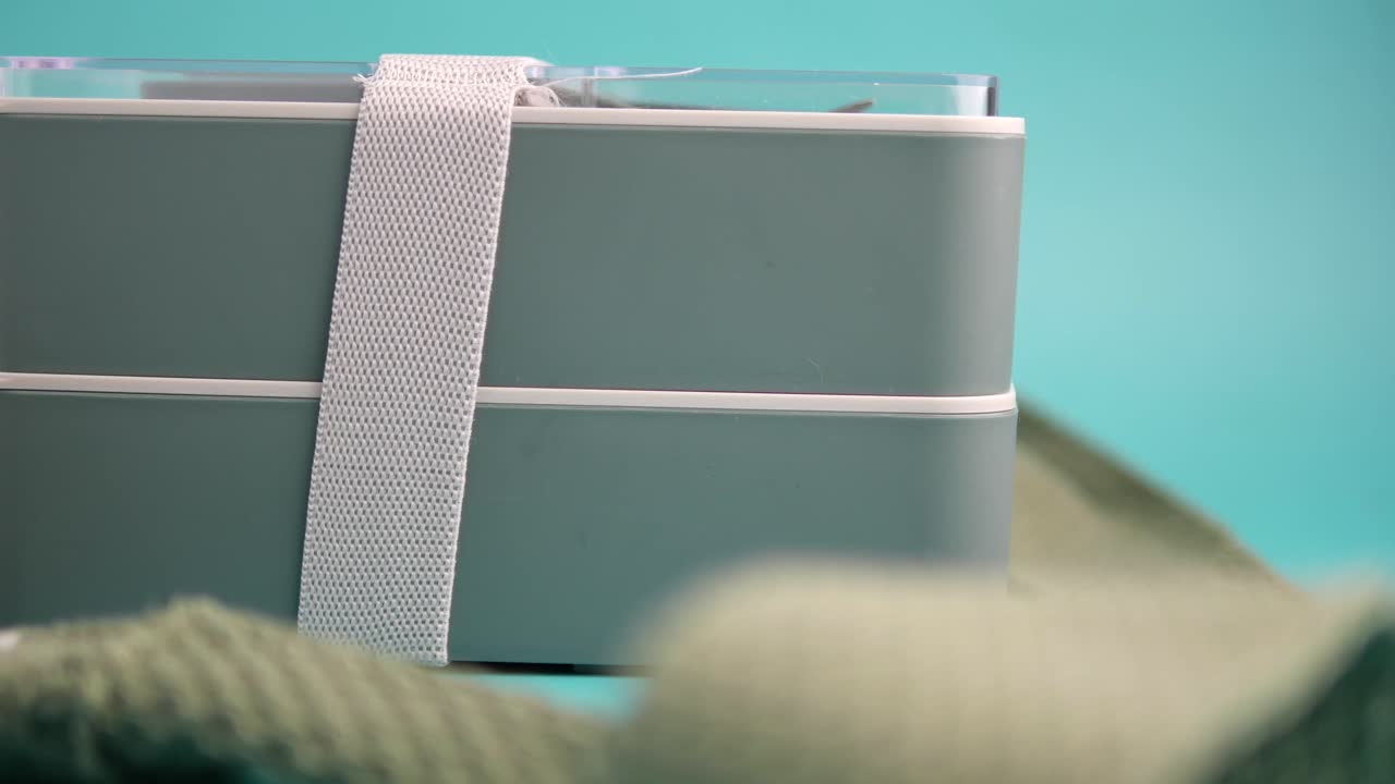 Šedý bento box s bílým popruhem