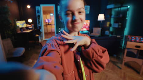 Kid-films-POV-style-dance-tutorial-video-with-smartphone-in-blue-neon-lit-living-room