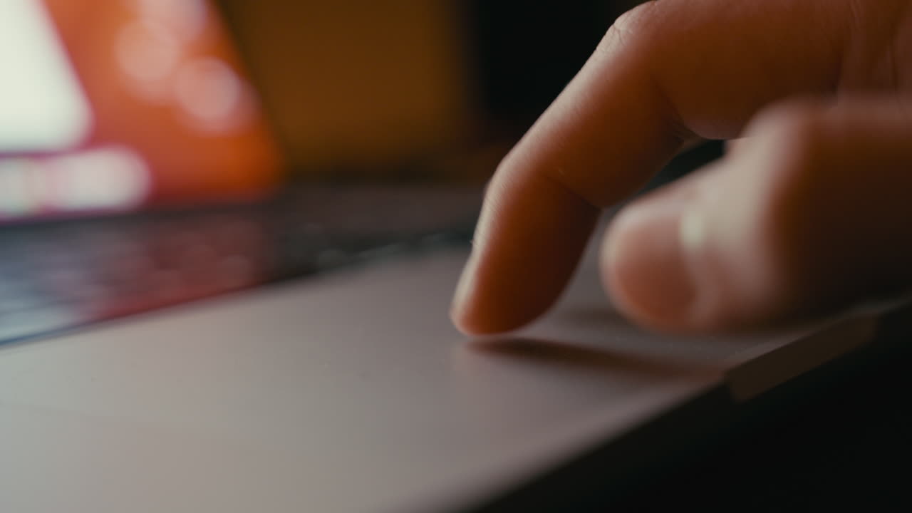 Finger on Laptop Touchpad at Night