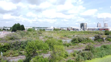 Industrial-warehouse-power-plant-refinery-buildings-under-smokestack-wasteland-aerial-view